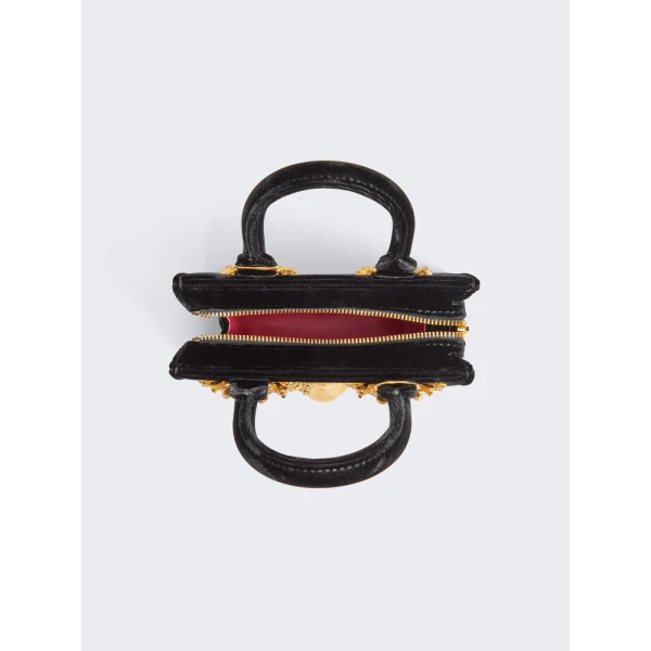 Schiaparelli Mini Anatomy Jewelry Bag in black velvet featuring gold nose and mouth hardware (Face Bag)