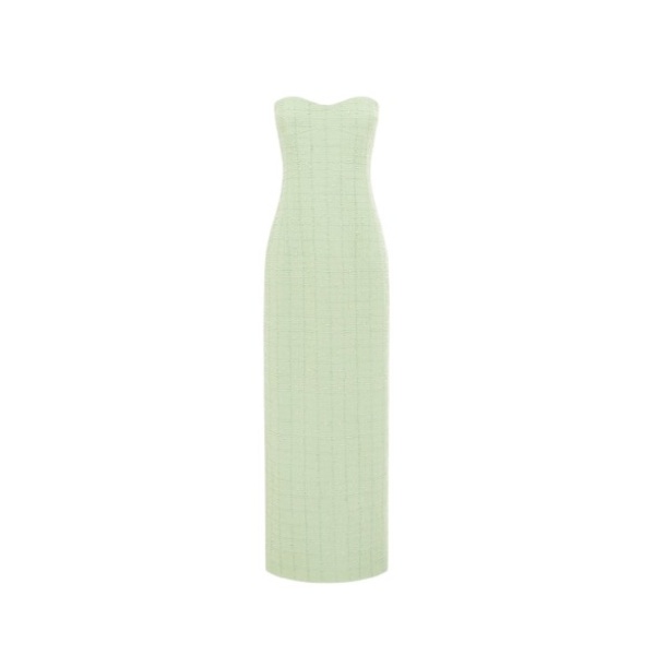 Leo Lin Zayna tweed bustier maxi dress in a light green color, featuring a strapless boned bodice, a fitted waist, and a gently flared skirt with a high slit, modeled by a person with light brown hair posing gracefully.