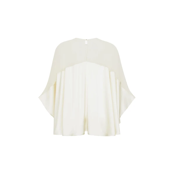 the Apollo Top is crafted from luxurious 100% silk in a soft cream hue. The flowing
