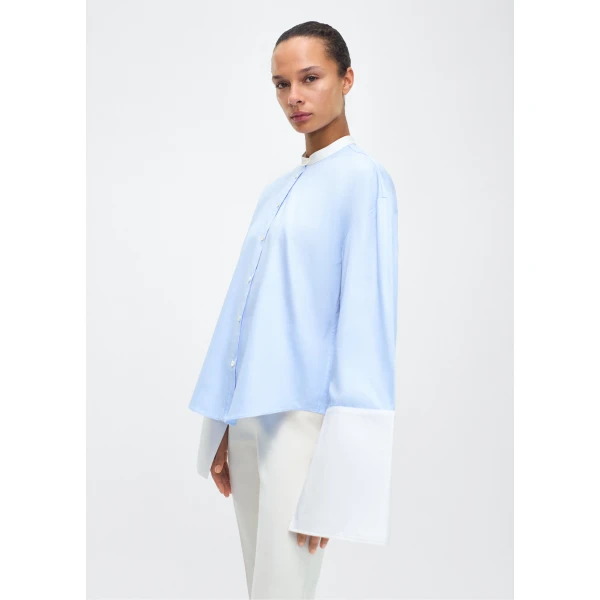 with a subtle slit near the cuffs for added detail. Made from the highest quality cotton and featuring diamond monogram mother of pearl buttons down the center front