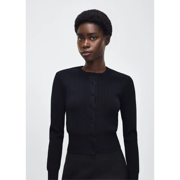 the piece is finished with covered buttons along the front placket for a refined look.