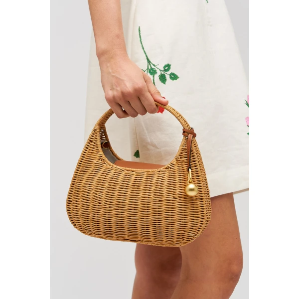 Profile view of model wearing the Oroton Clara Wicker Mini Bag in Natural/Cognac and Woven wicker exterior for Women