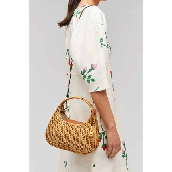 Profile view of model wearing the Oroton Clara Wicker Mini Bag in Natural/Cognac and Woven wicker exterior for Women
