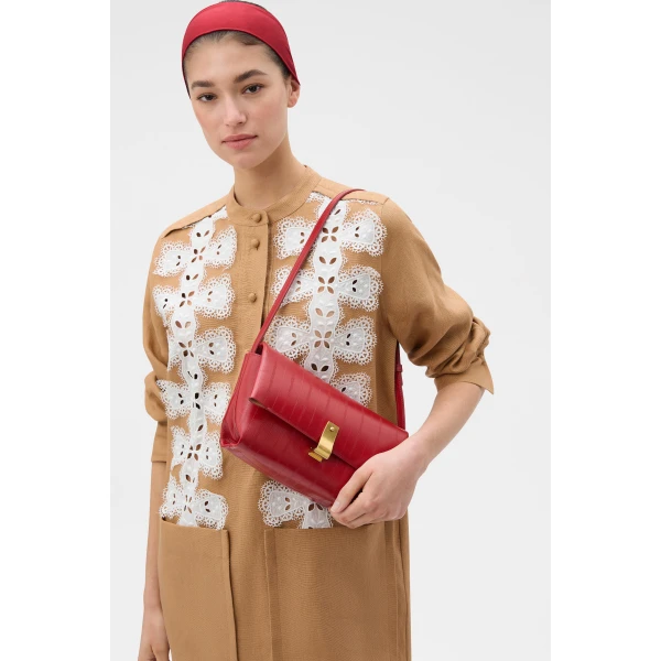 Profile view of model wearing the Oroton ETTA MEDIUM CLUTCH EEL in LAVA and Premium embossed leather for Women