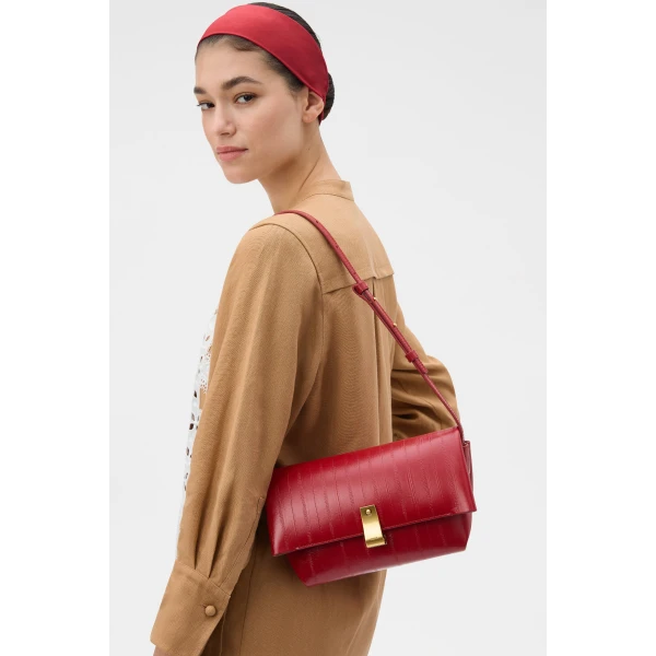 Profile view of model wearing the Oroton ETTA MEDIUM CLUTCH EEL in LAVA and Premium embossed leather for Women