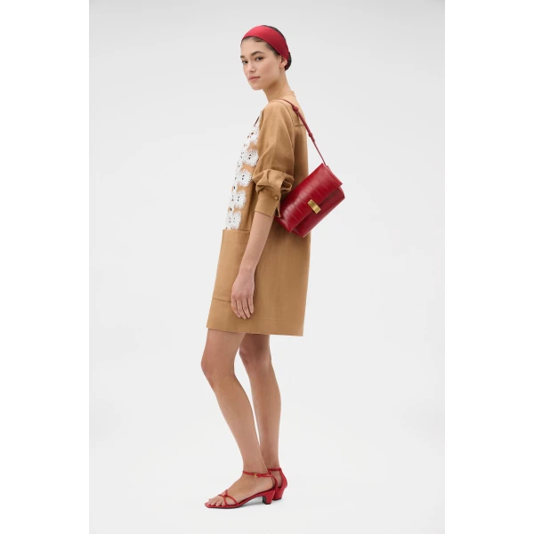 Profile view of model wearing the Oroton ETTA MEDIUM CLUTCH EEL in LAVA and Premium embossed leather for Women
