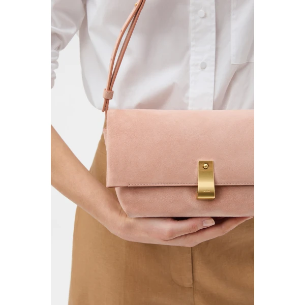 Profile view of model wearing the Oroton ETTA MEDIUM CLUTCH SUEDE in MELON and Premium suede leather for Women