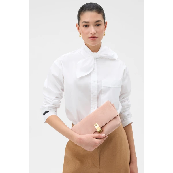 Profile view of model wearing the Oroton ETTA MEDIUM CLUTCH SUEDE in MELON and Premium suede leather for Women