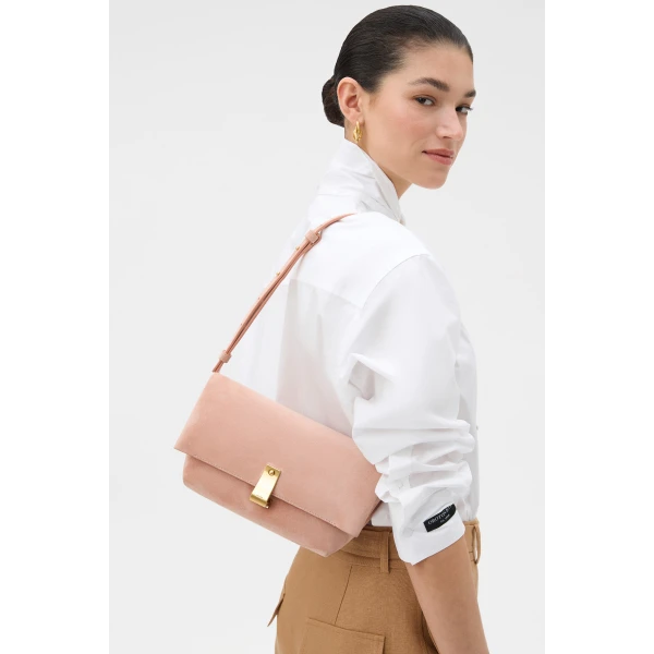 Profile view of model wearing the Oroton ETTA MEDIUM CLUTCH SUEDE in MELON and Premium suede leather for Women