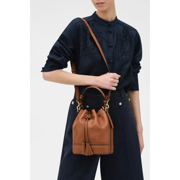Profile view of model wearing the Oroton MAGGIE BUCKET BROGUING in COGNAC and Premium smooth leather for Women