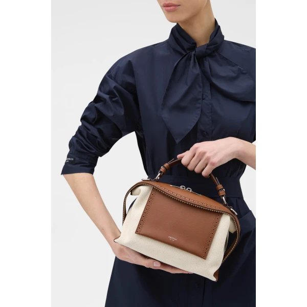 Profile view of model wearing the Oroton MICA BOWLER CANVAS BROGUING in NATURAL/PENNY BROWN and Premium canvas material for Women