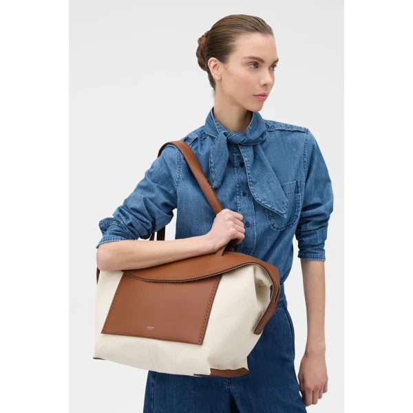 Profile view of model wearing the Oroton MICA MEDIUM TOTE CANVAS BROGUING in NATURAL/PENNY BROWN and Premium canvas material for Women