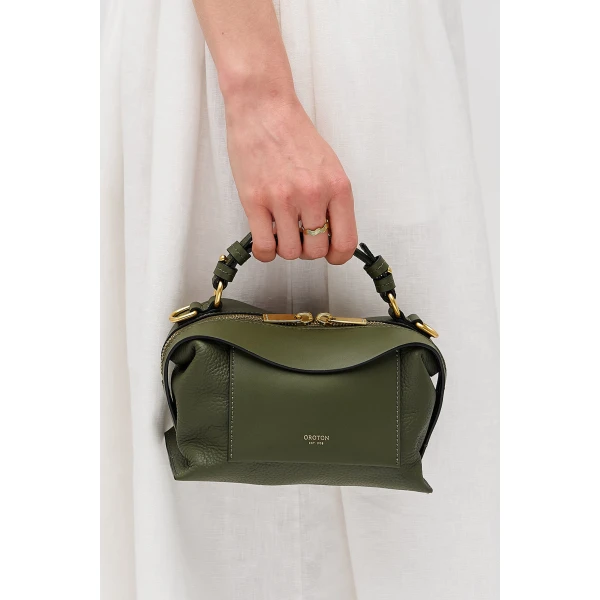 Profile view of model wearing the Oroton MICA MINI BOWLER in Dark Khaki and Premium pebble leather for Women