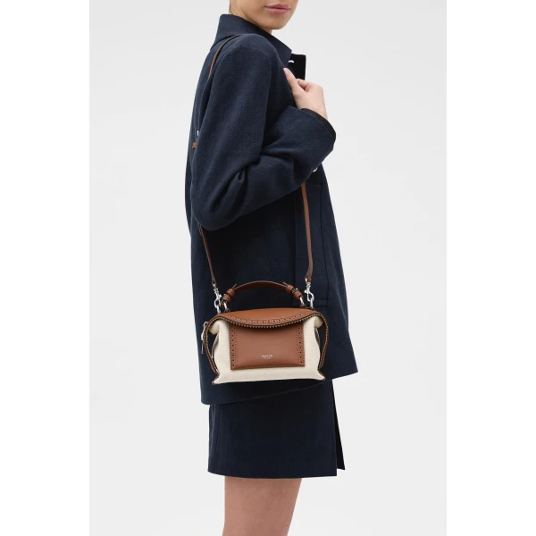 Profile view of model wearing the Oroton MICA MINI BOWLER CANVAS BROGUING in NATURAL/PENNY BROWN and Premium canvas material for Women