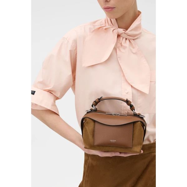 Profile view of model wearing the Oroton MICA MINI BOWLER SUEDE in TEAK and Premium suede leather for Women