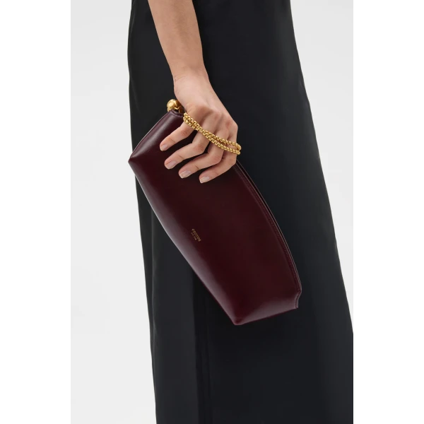 Profile view of model wearing the Oroton NAIA CLUTCH in CURRANT and Premium crackle leather for Women