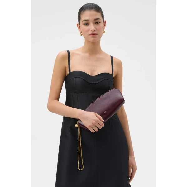 Profile view of model wearing the Oroton NAIA CLUTCH in CURRANT and Premium crackle leather for Women