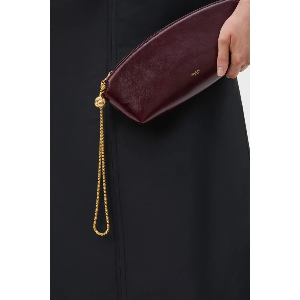 Profile view of model wearing the Oroton NAIA CLUTCH in CURRANT and Premium crackle leather for Women