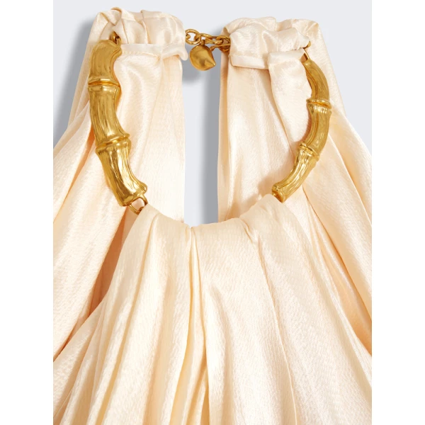 Schiaparelli black dress featuring gold bamboo shaped hardware straps and buttons