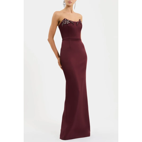 its strapless scoop neckline and fitted bodice with internal boning sculpt a feminine shape